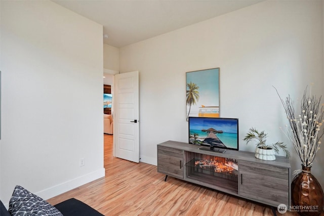 living area featuring baseboards and wood finished floors