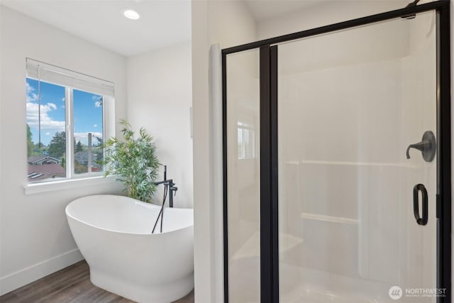 full bath with recessed lighting, baseboards, a freestanding tub, wood finished floors, and a stall shower