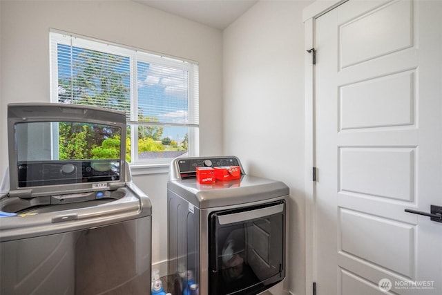 clothes washing area featuring separate washer and dryer and laundry area