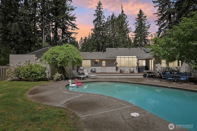 pool at dusk featuring a patio