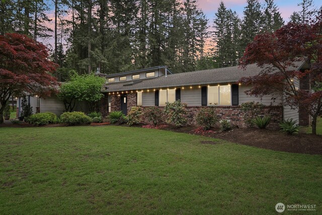 view of front of property with a yard and brick siding