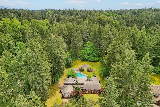 bird's eye view of a heavily wooded area and a pool