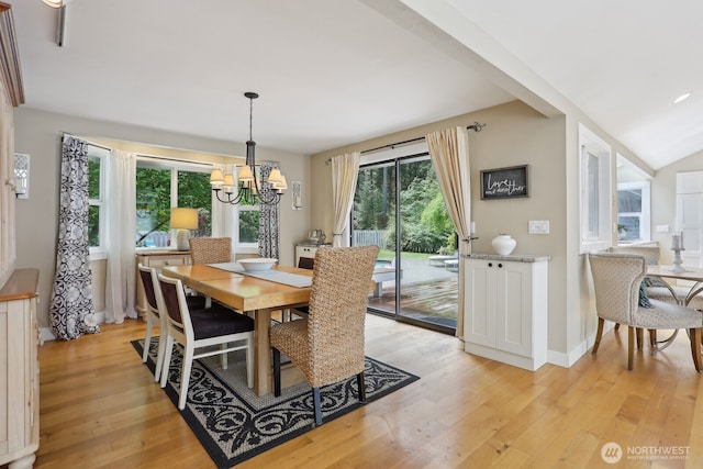 dining area with a chandelier, light wood finished floors, and baseboards