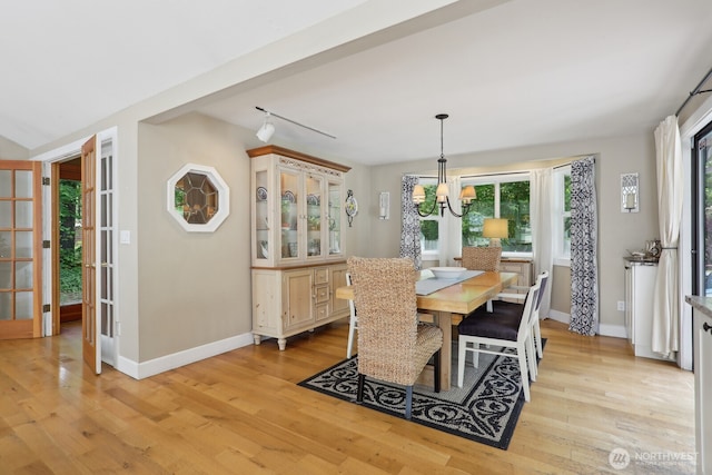 dining space featuring plenty of natural light, light wood finished floors, and a chandelier