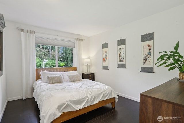 bedroom featuring dark wood-style flooring and baseboards