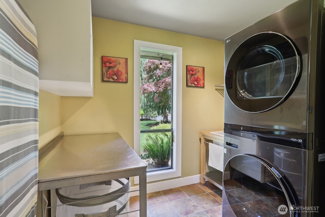 washroom featuring estacked washer and dryer and baseboards