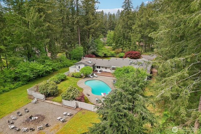view from above of property featuring a pool and a forest
