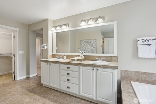 25510 SE 275th Pl, Maple Valley, WA 98038 - bathroom featuring double vanity, a relaxing tiled tub, a walk in closet, and tile patterned floors