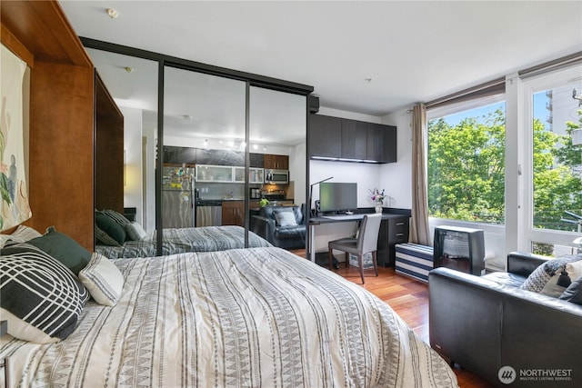 4547 8th Ave NE Unit 308, Seattle, WA 98105 - bedroom featuring wood finished floors, a closet, and freestanding refrigerator