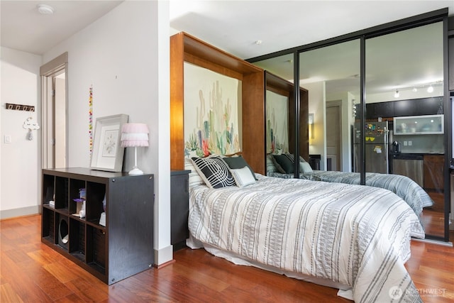 4547 8th Ave NE Unit 308, Seattle, WA 98105 - bedroom featuring freestanding refrigerator and wood finished floors