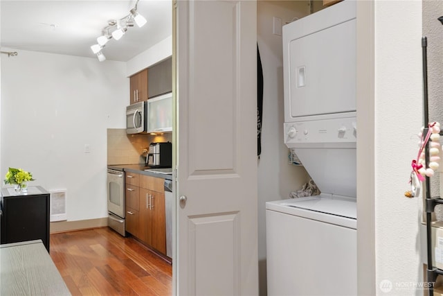 4547 8th Ave NE Unit 308, Seattle, WA 98105 - washroom with light wood-style floors, stacked washer / drying machine, and laundry area