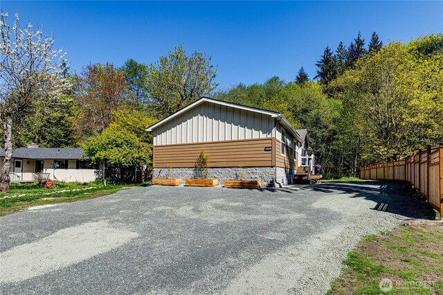 view of property exterior with board and batten siding and fence