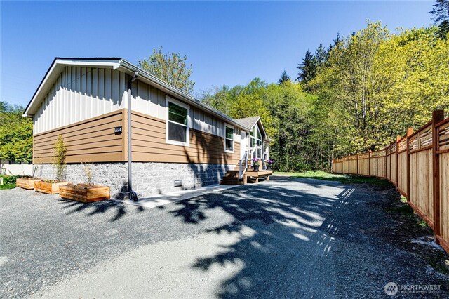 view of side of property with fence and board and batten siding