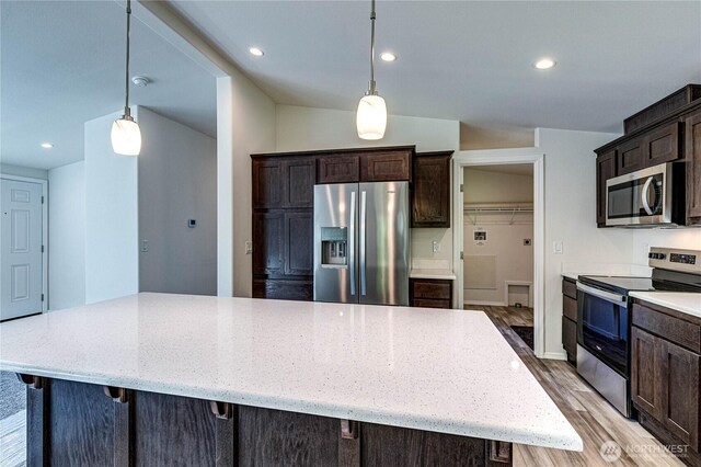 kitchen with light wood-style flooring, stainless steel appliances, dark brown cabinets, light stone countertops, and recessed lighting