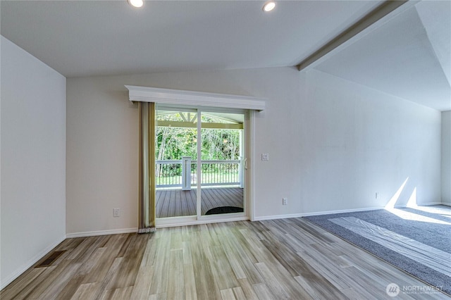 empty room with visible vents, light wood-style flooring, vaulted ceiling with beams, and baseboards