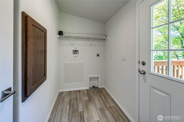 clothes washing area featuring light wood finished floors, washer hookup, laundry area, electric dryer hookup, and baseboards