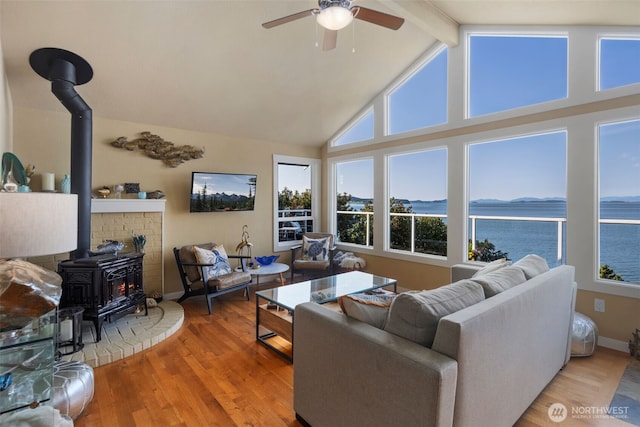 192 Fay Ln, Camano Island, WA 98282 - living room with a healthy amount of sunlight, beamed ceiling, a ceiling fan, and a wood stove