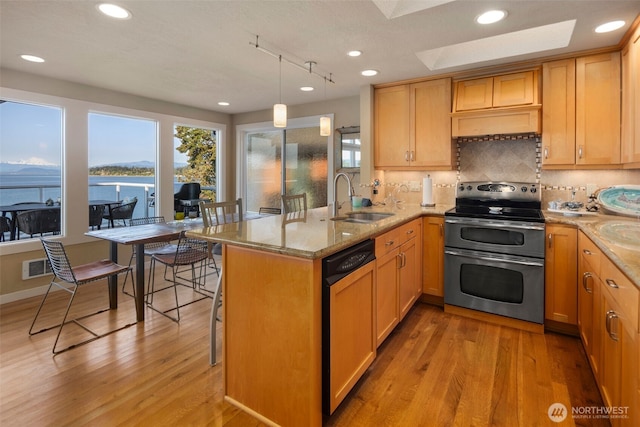 192 Fay Ln, Camano Island, WA 98282 - kitchen with double oven range, dishwasher, a sink, a peninsula, and light wood-style floors