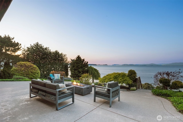 192 Fay Ln, Camano Island, WA 98282 - patio terrace at dusk featuring a water view and an outdoor living space with a fire pit