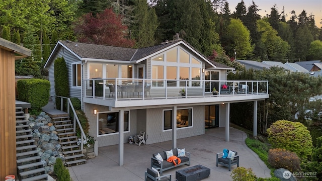 192 Fay Ln, Camano Island, WA 98282 - back of house at dusk with stairway, a patio, and an outdoor living space with a fire pit