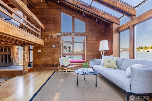 3123 Fairview Ave E Unit 2, Seattle, WA 98102 - living room featuring high vaulted ceiling, beamed ceiling, wooden walls, a water view, and hardwood / wood-style floors