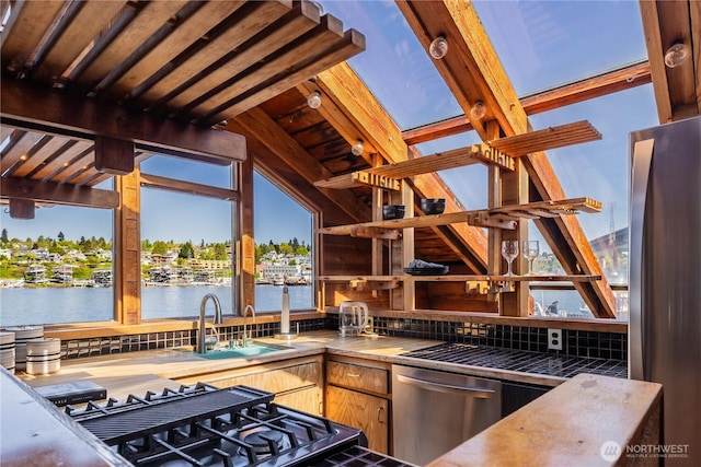 3123 Fairview Ave E Unit 2, Seattle, WA 98102 - kitchen with open shelves, a sink, stainless steel appliances, lofted ceiling, and a water view