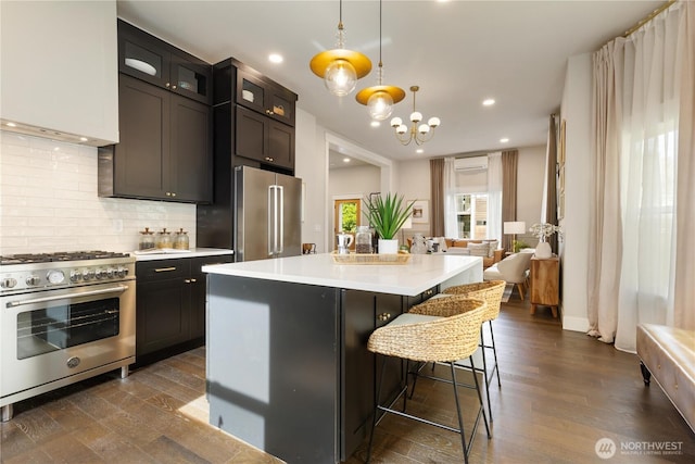 421 Malden Ave E, Seattle, WA 98112 - kitchen with high end appliances, a wall mounted AC, decorative backsplash, dark wood-type flooring, and recessed lighting