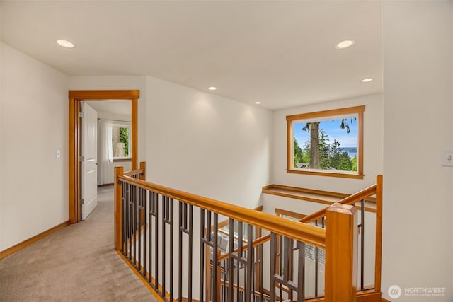 hallway featuring recessed lighting, baseboards, carpet floors, and an upstairs landing
