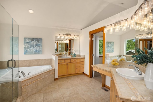 bathroom with tile patterned floors, a sink, a garden tub, and a stall shower