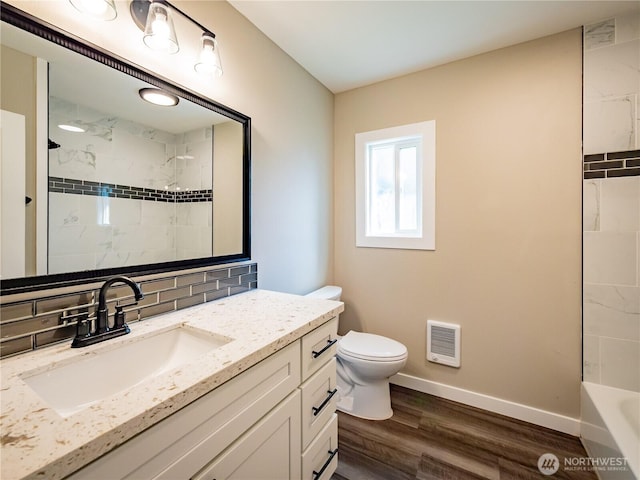 full bathroom featuring heating unit, tasteful backsplash, toilet, baseboards, and wood finished floors