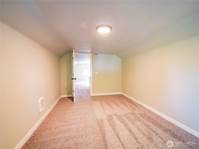 bonus room featuring lofted ceiling, carpet flooring, and baseboards
