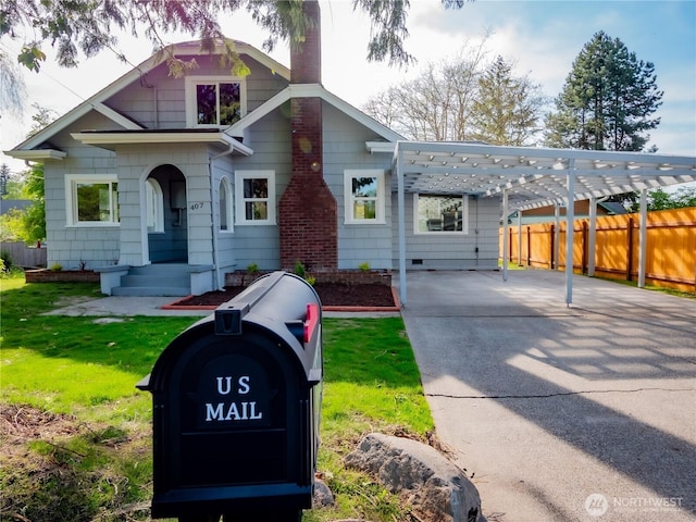view of front of house featuring a chimney, fence, a front lawn, and concrete driveway