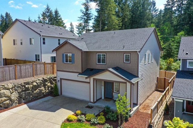 traditional-style home featuring a porch, a garage, fence, concrete driveway, and a shingled roof