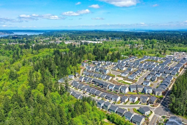 drone / aerial view featuring a residential view and a forest view