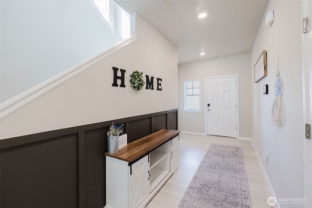 doorway with baseboards, light wood-type flooring, and recessed lighting