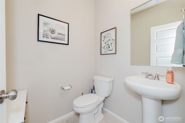 bathroom featuring toilet, baseboards, visible vents, and a sink