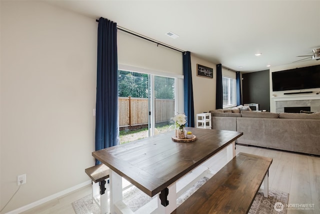 dining area featuring visible vents, a fireplace, recessed lighting, a ceiling fan, and light wood finished floors