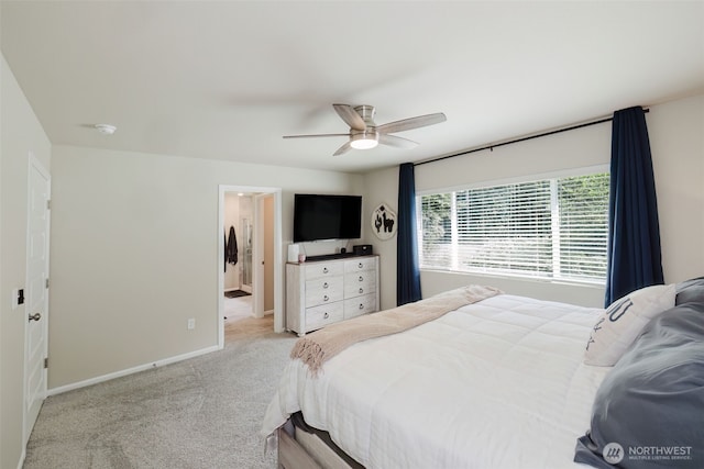 carpeted bedroom featuring baseboards, a ceiling fan, and ensuite bath