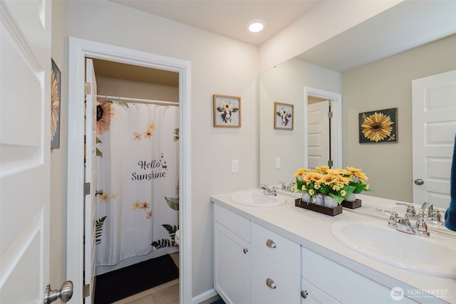 full bathroom featuring a sink and double vanity