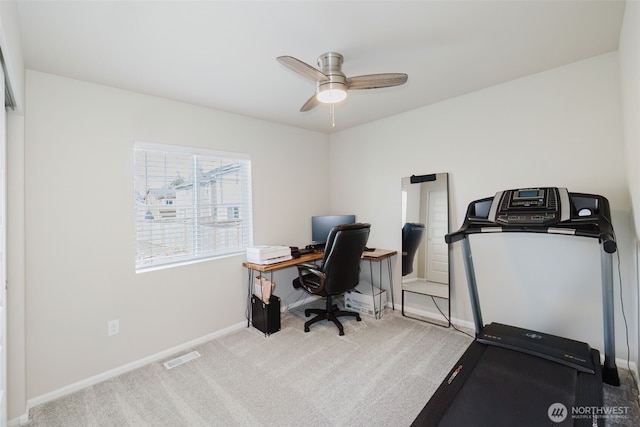 carpeted office space featuring visible vents, a ceiling fan, and baseboards