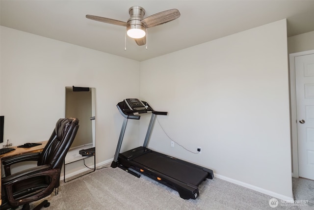 exercise room featuring baseboards, ceiling fan, and light colored carpet