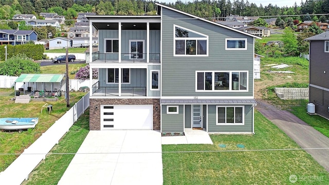 152 Henning Dr, Camano Island, WA 98282 - view of front facade featuring board and batten siding, a balcony, concrete driveway, a garage, and a residential view