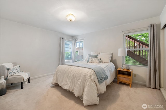 bedroom with baseboards, multiple windows, and light carpet