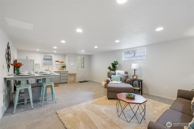 living area featuring recessed lighting and baseboards