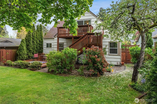 back of house featuring fence, a wooden deck, a yard, and stairway