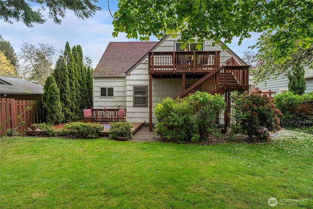rear view of property with fence, a yard, and a deck