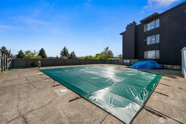 pool with a patio and fence
