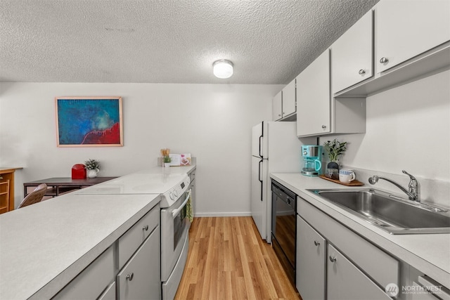 kitchen featuring a sink, electric range oven, light wood-style flooring, and light countertops