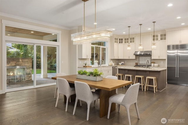 dining room with dark wood-style floors, recessed lighting, and ornamental molding