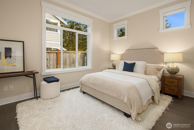 bedroom with wood finished floors, baseboards, and crown molding